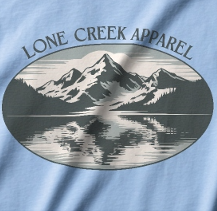 Light blue t-shirt with a mountain graphic and 'Lone Creek Apparel' text.