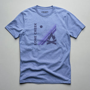 Geometric campfire graphic in purple and grey tones on a Heather Blue cotton tee.