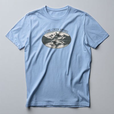 Light blue t-shirt with mountain graphic and 'Lone Creek Apparel' text on a gray background