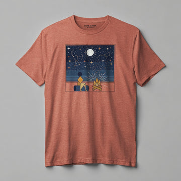 Geometric campfire and constellation scene in navy, amber, and gold on a Clay Brown graphic tee