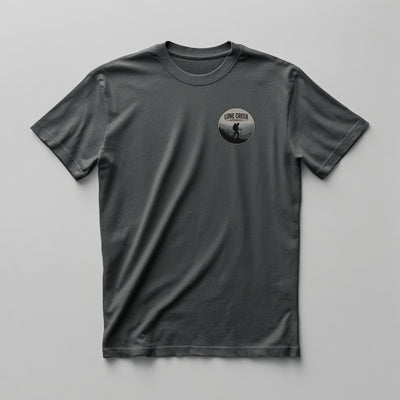 Circular hiker badge graphic in charcoal and sage on a Grey graphic tee