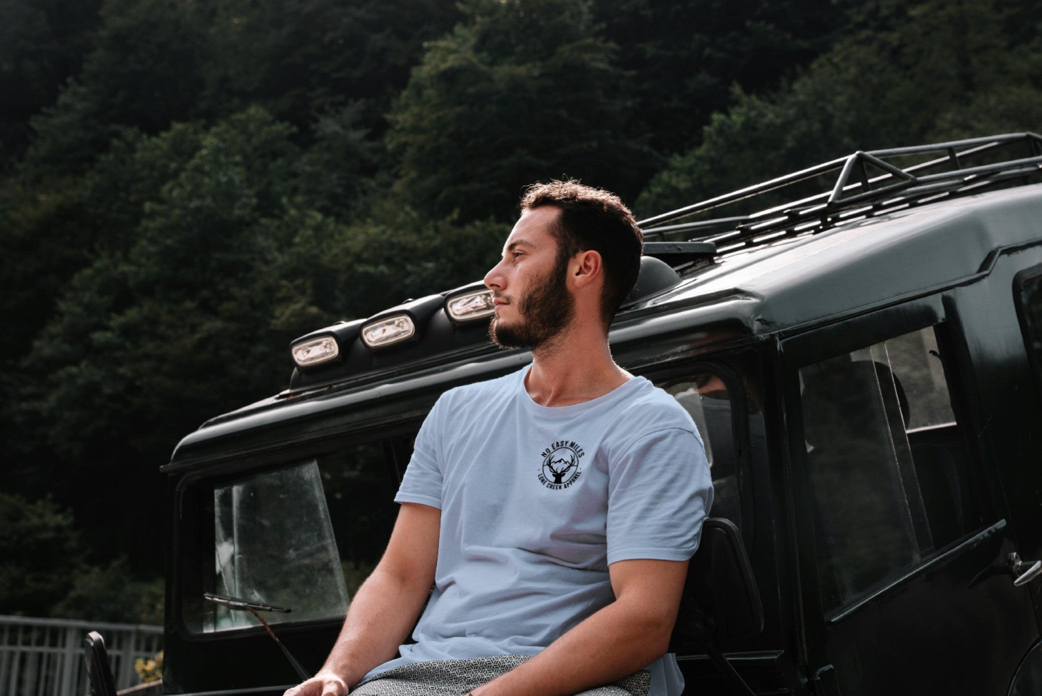 Man sitting on a vehicle with a forest background